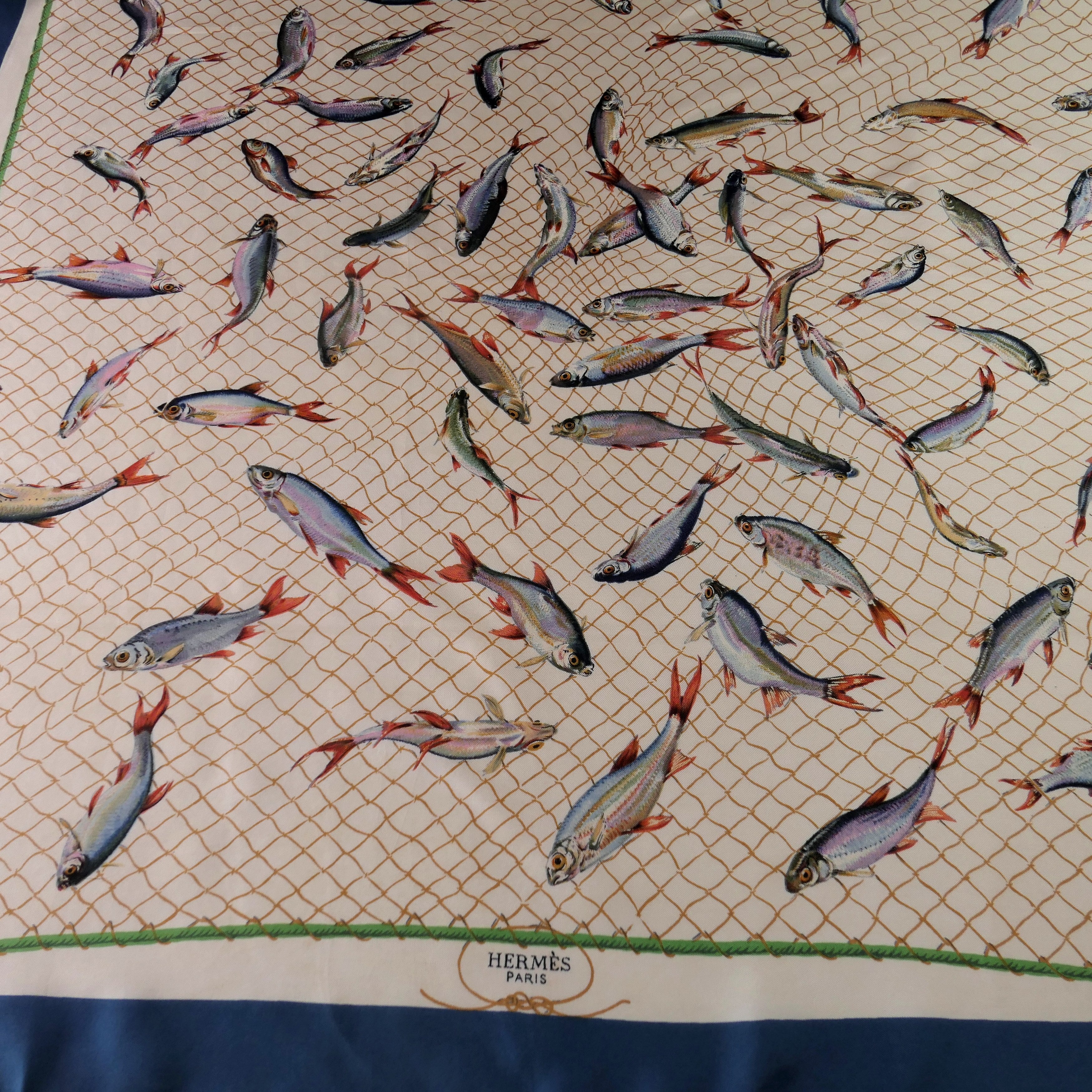 Carré Hermès Coup de Filet 90 cm soie, détail quart avec poissons et filet, bordure bleu pétrole