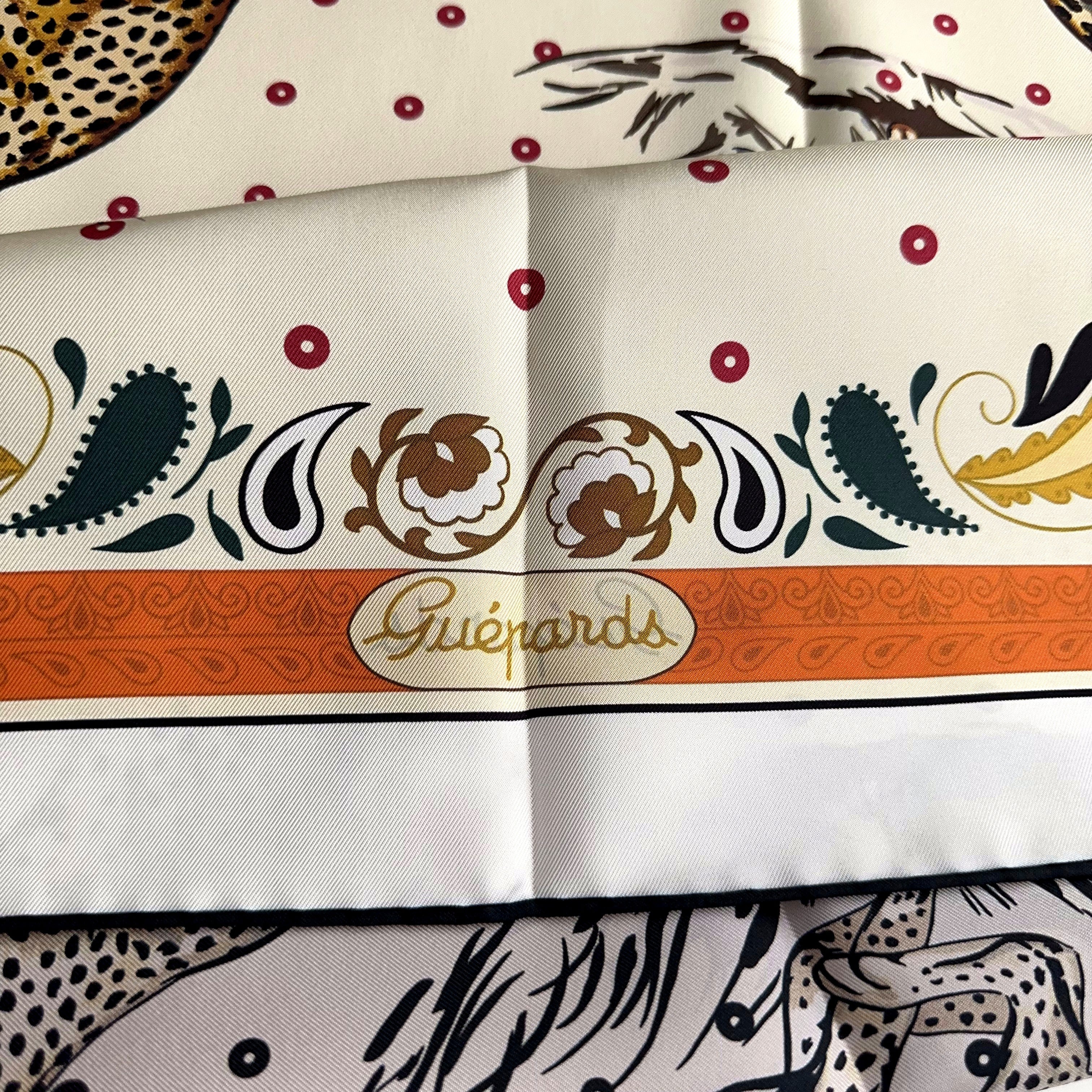 Carré Hermès Guépards Bandana de Robert Dallet, 90 cm soie, détail du pliage avec titre Guépards