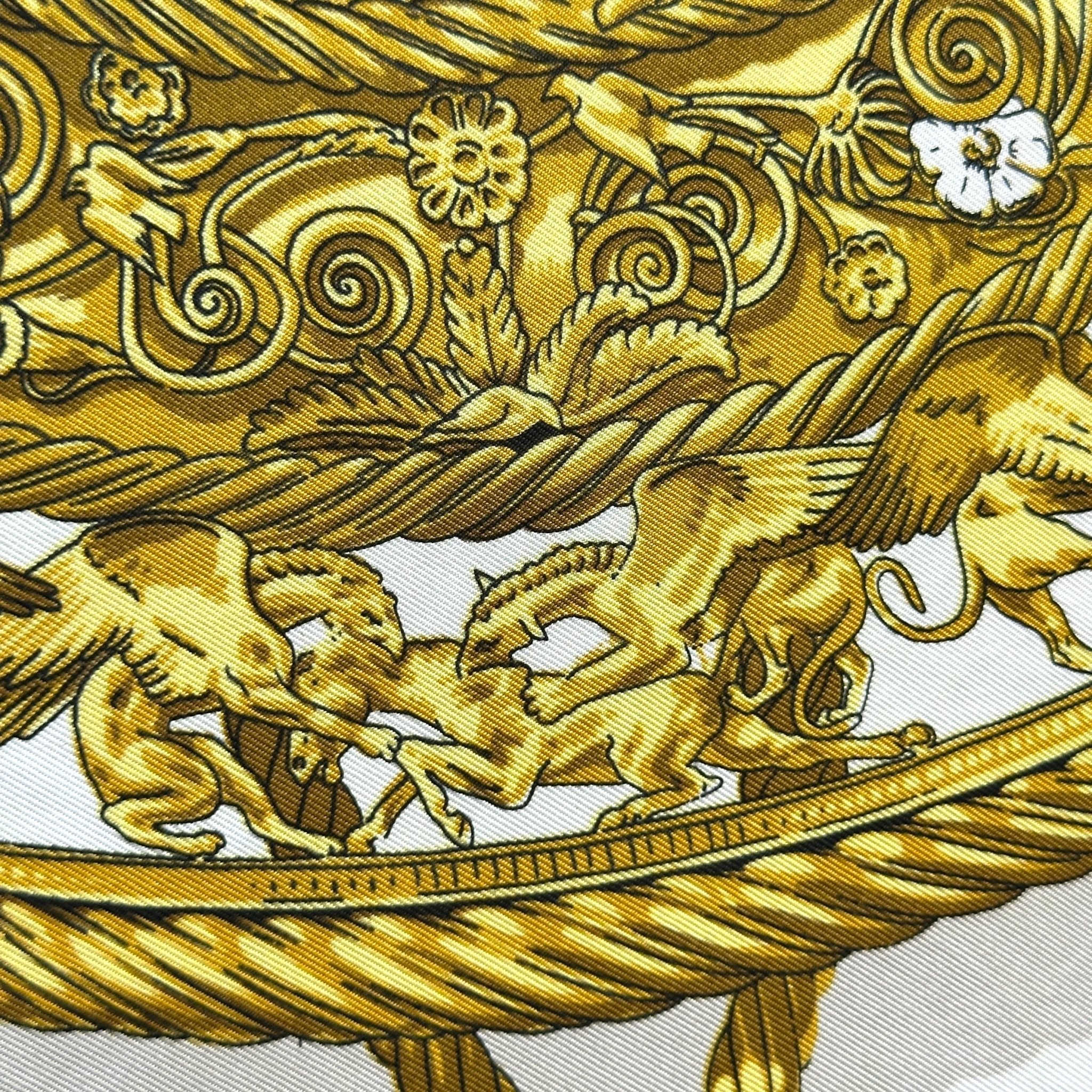 Zoom sur le motif central du foulard Hermès Les Cavaliers d’Or, orfèvrerie scythe couleur or