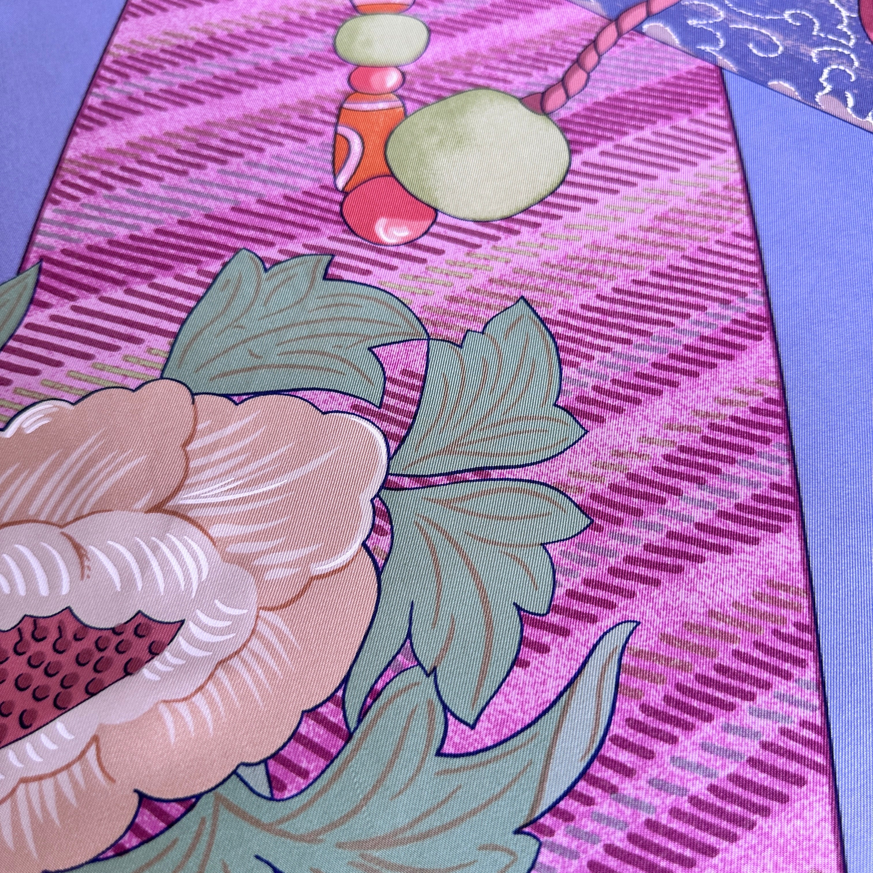 Zoom sur les ornements roses et violets au centre du carré Hermès.