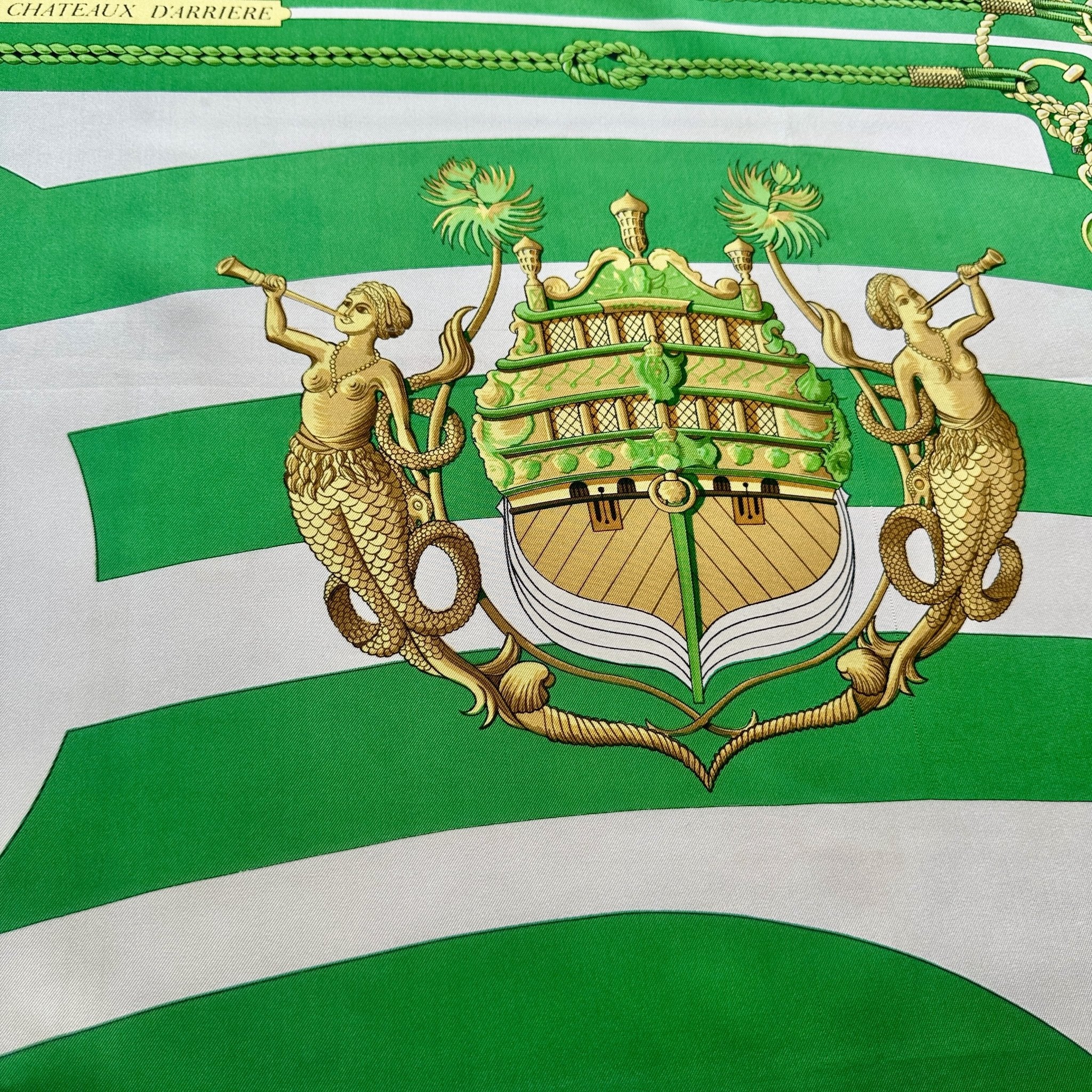 Détail d'un chateau arrière encadré par 2 sirènes soufflant dans une trompe