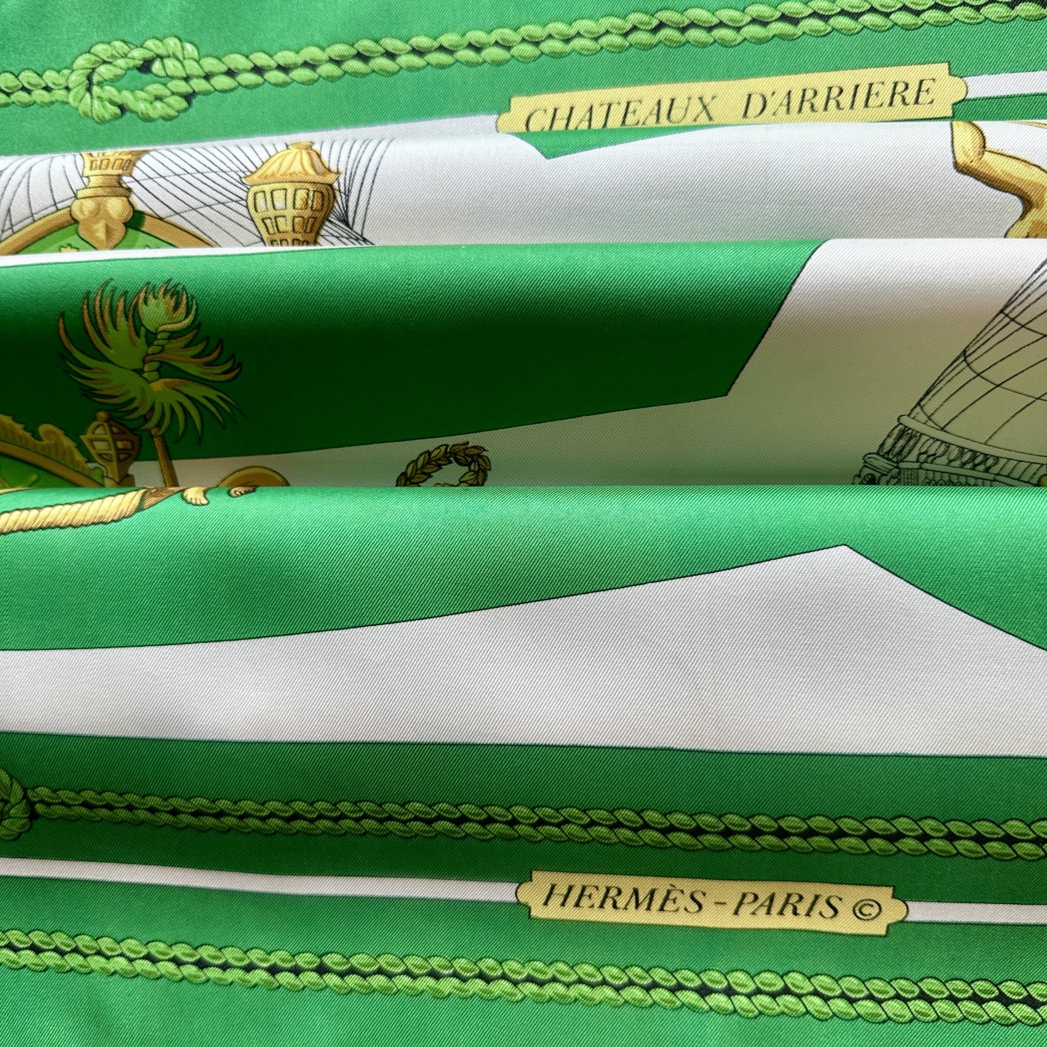 Vue du foulard Hermès vert blanc et or intitulé Chateaux d'arrière et présenté avec un effet plissé