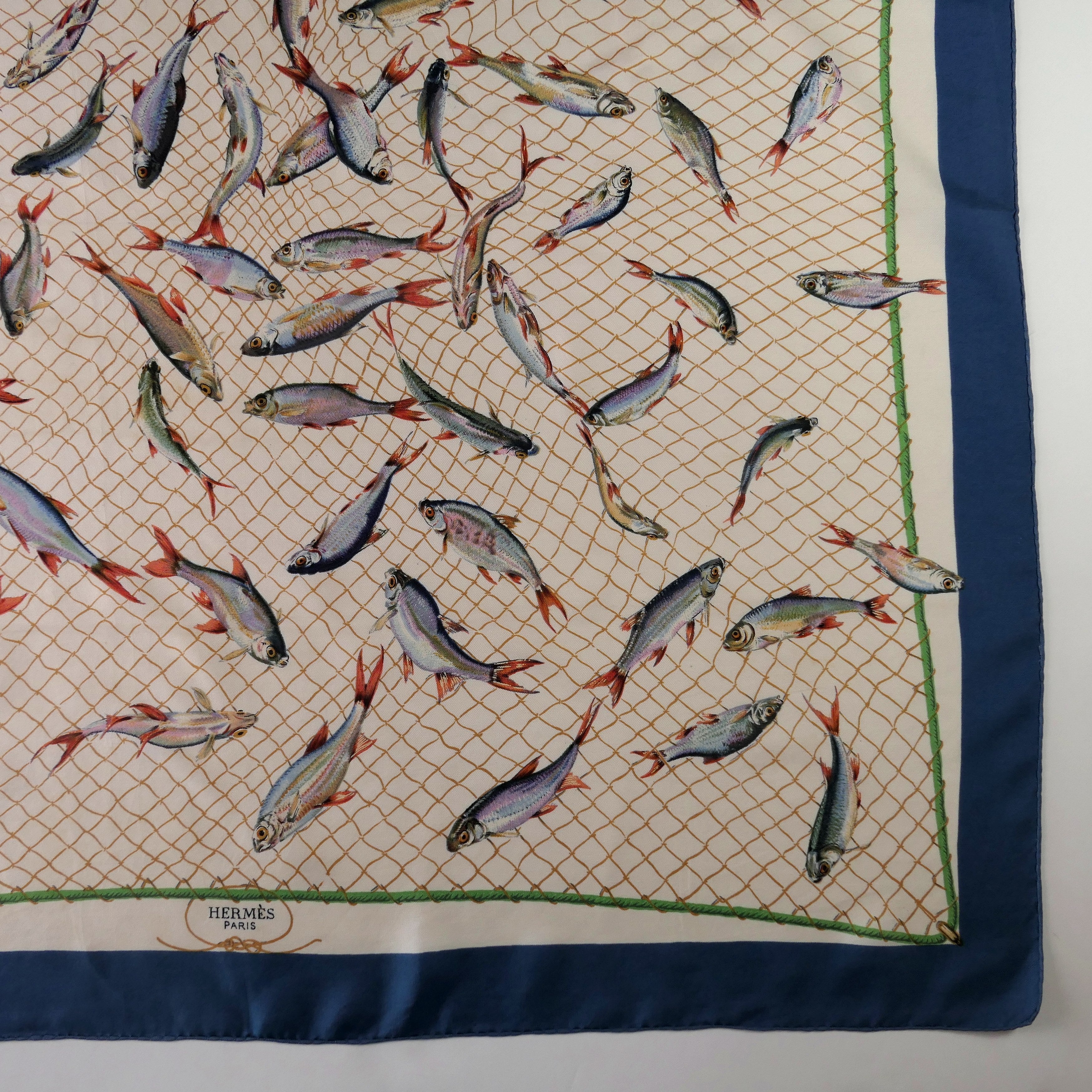 Carré Hermès Coup de Filet 90 cm soie, détail signature Hermès Paris, bordure bleu pétrole