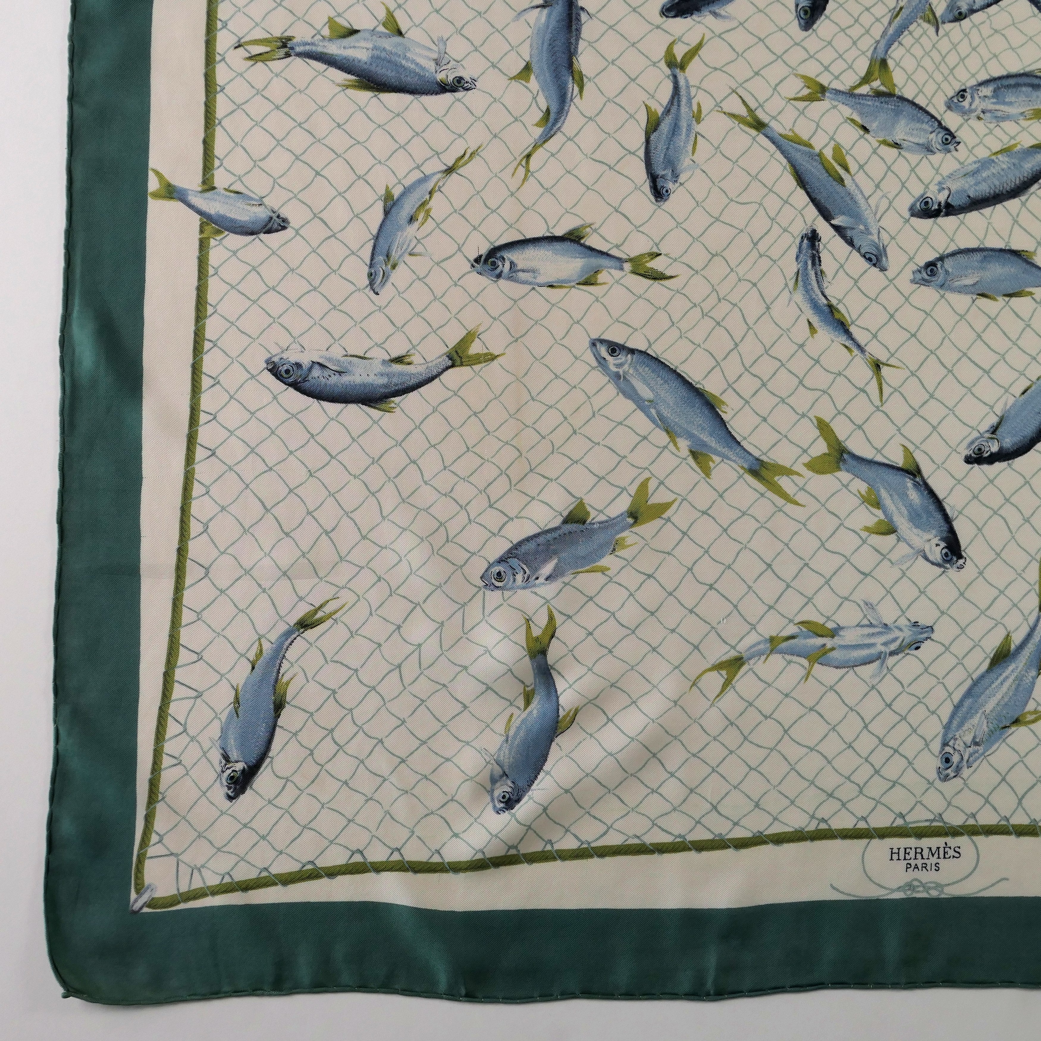 Carré Hermès Coup de Filet 90 cm soie, détail bordure verte et signature Hermès Paris