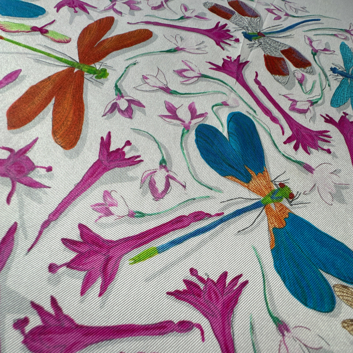 Carré Hermès Dragonflies Leigh Cooke 70 cm soie, détail libellule bleue parmi les fleurs fuchsia
