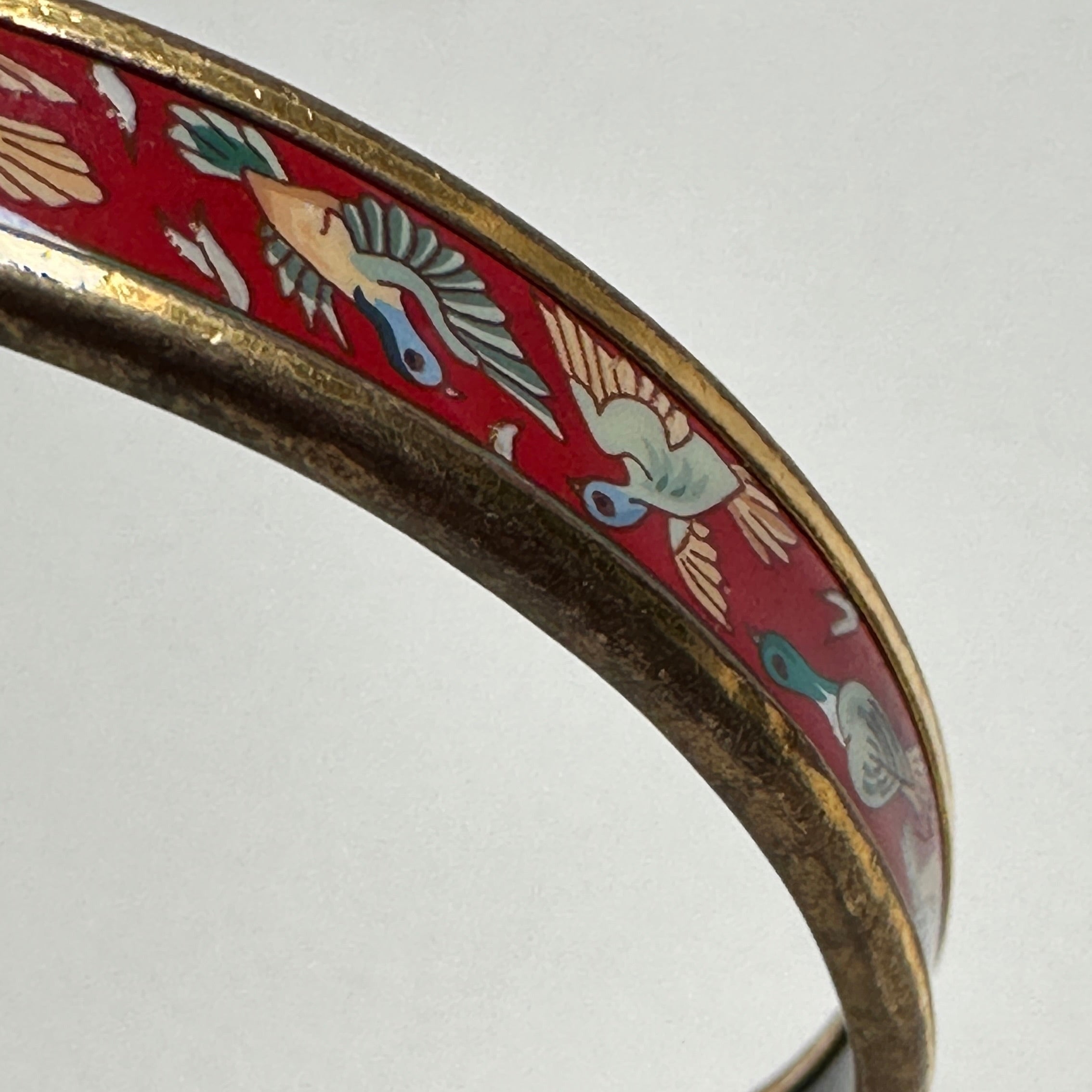 Bracelet rigide Hermès femme, modèle jonc fin (Narrow) rouge et or, illustration d'oiseaux à l'envol un peu usé