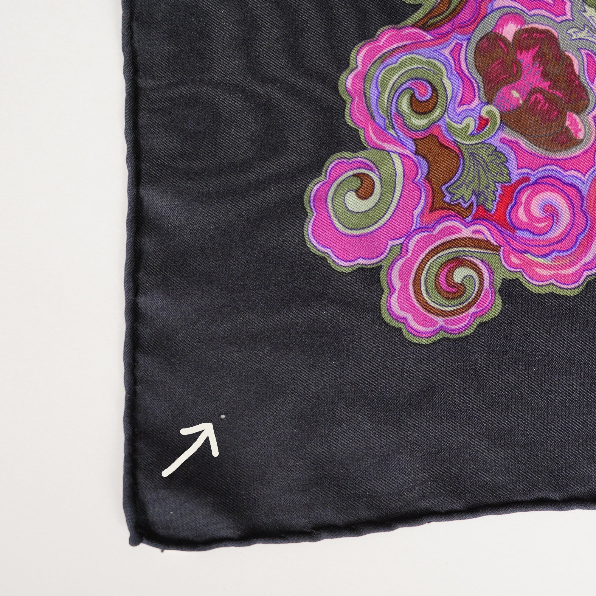 Détail de la soie sur le foulard vintage Hermès, une flèche indique l'un des micro-trous de la taille d'une tête d'épingle.