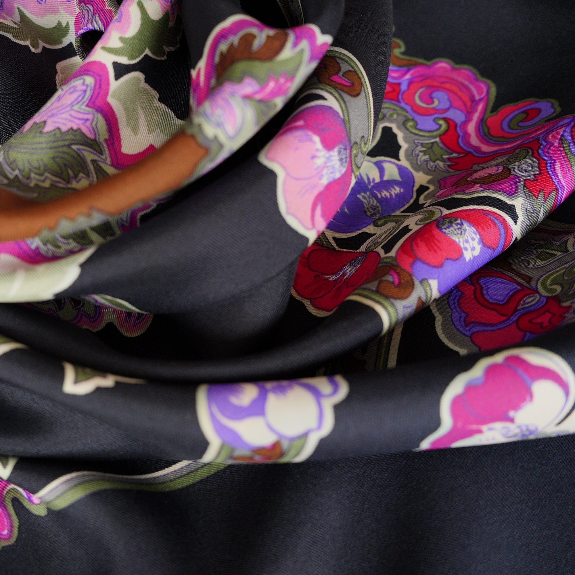 Le carré de soie Hermès "Anémones" drapé, illustrant le rendu dramatique et chic du coloris noir porté.