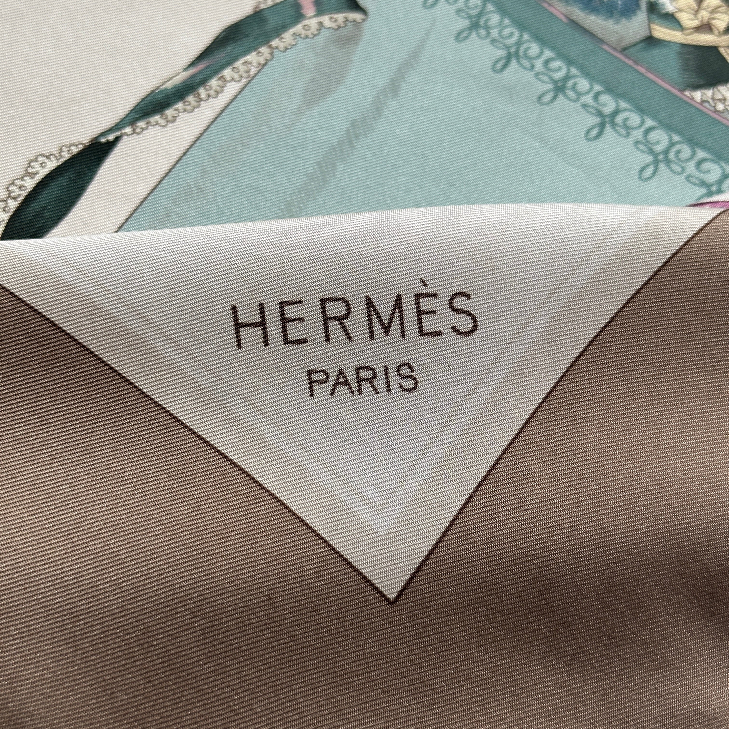 Signature "HERMÈS - PARIS" imprimée dans le coin bas droit sur le fond crème.